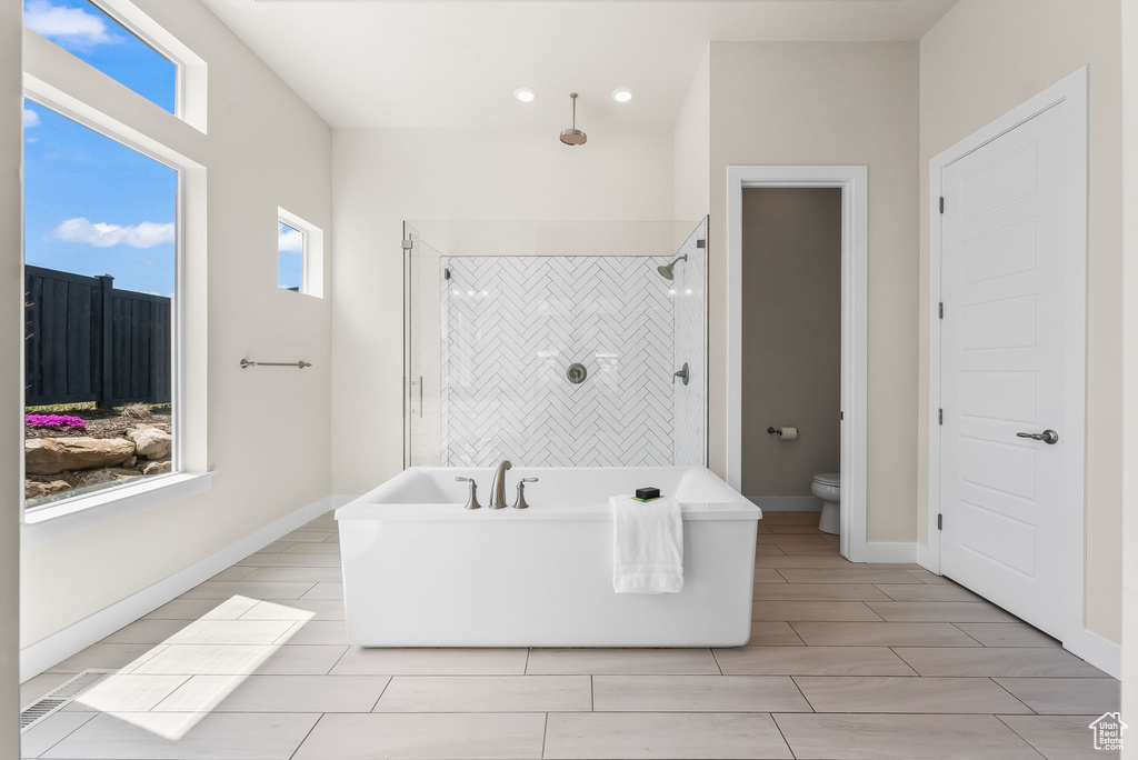 Bathroom with toilet, tile flooring, and independent shower and bath