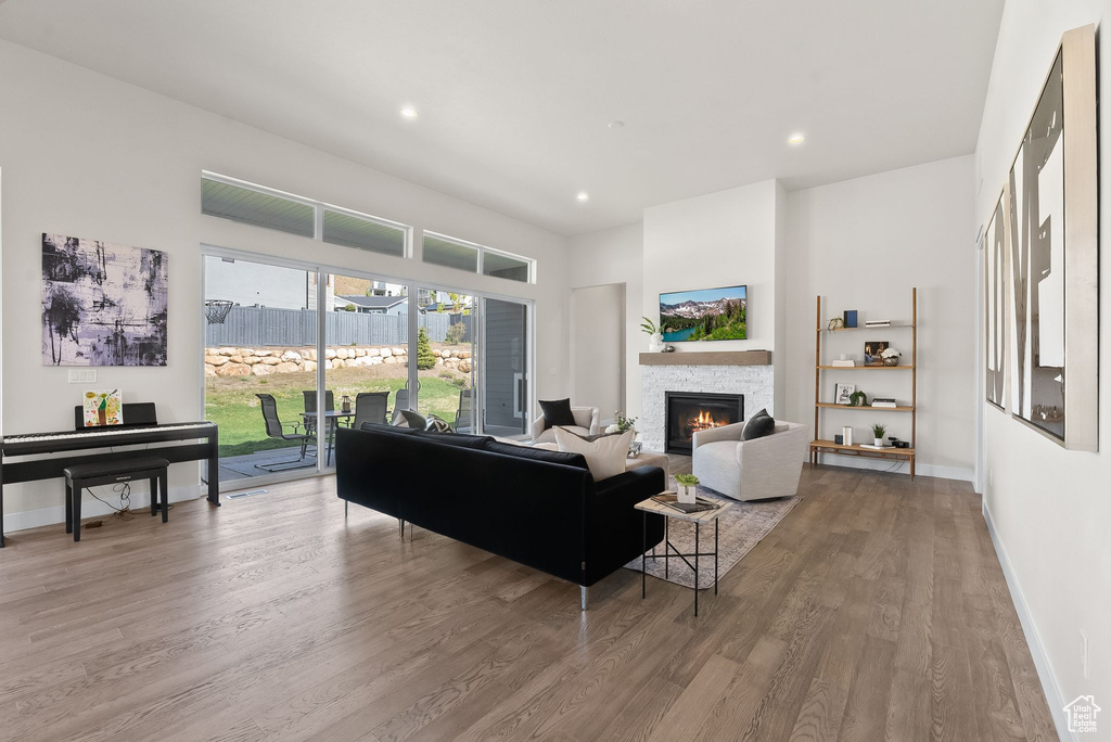 Living room with wood-type flooring and a stone fireplace