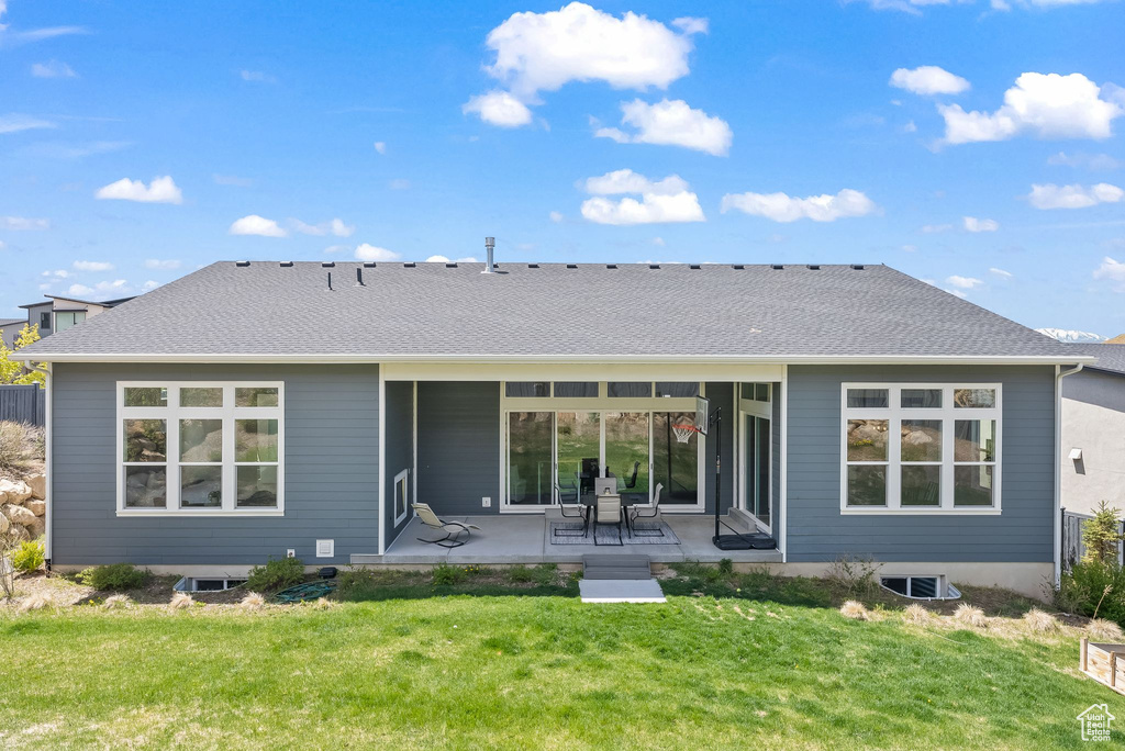 Back of property with a yard and a patio