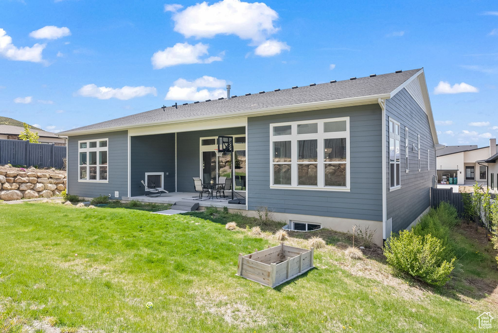 Back of property with a yard and a patio