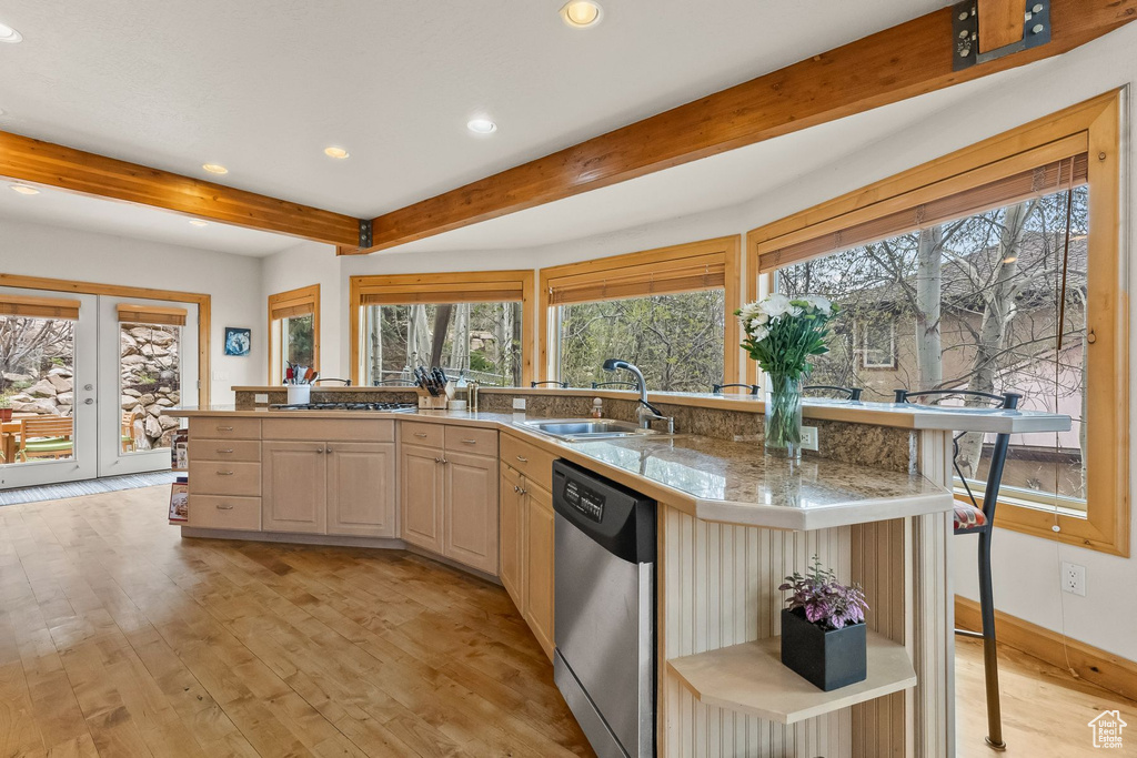 Kitchen featuring light hardwood / wood-style flooring, light brown cabinets, stainless steel appliances, beam ceiling, and sink