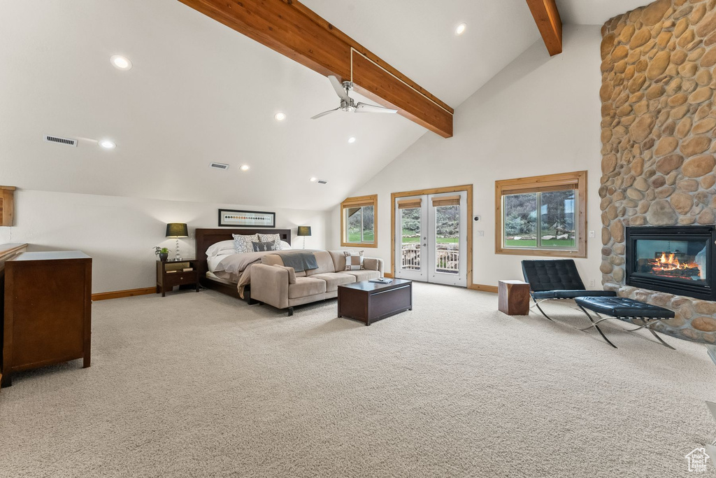 Carpeted bedroom featuring a stone fireplace, high vaulted ceiling, access to exterior, beam ceiling, and french doors