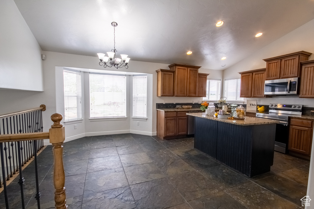 Kitchen with a kitchen island, vaulted ceiling, dark tile floors, and electric range