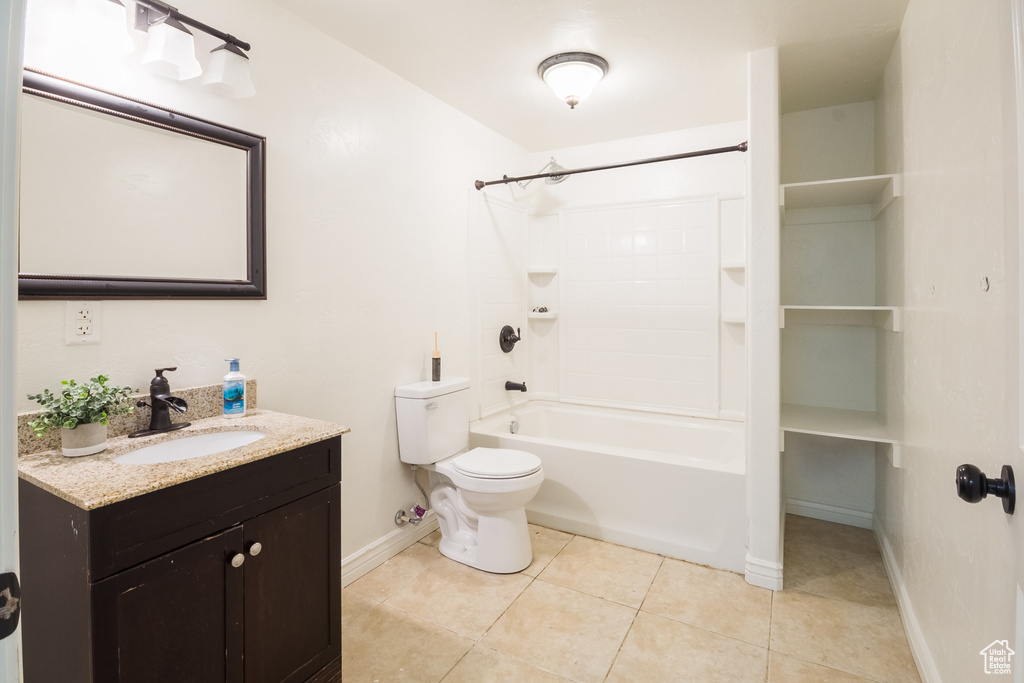 Full bathroom featuring shower / tub combination, toilet, vanity with extensive cabinet space, and tile flooring