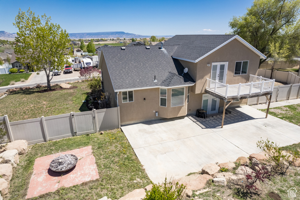 Back of property featuring a patio, a lawn, a mountain view, and central AC unit