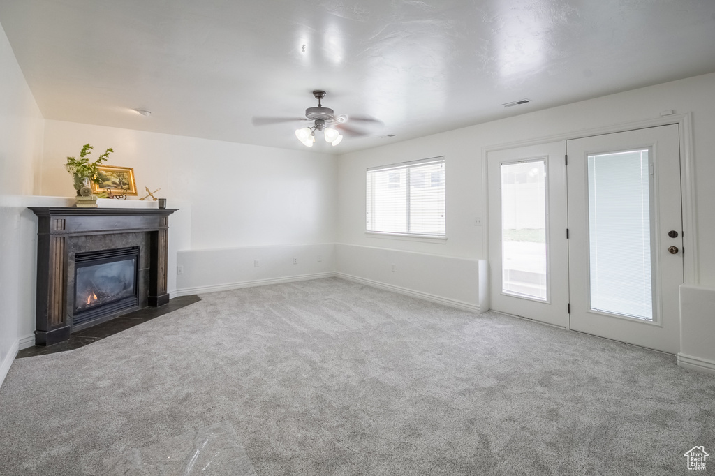Unfurnished living room with ceiling fan and carpet flooring