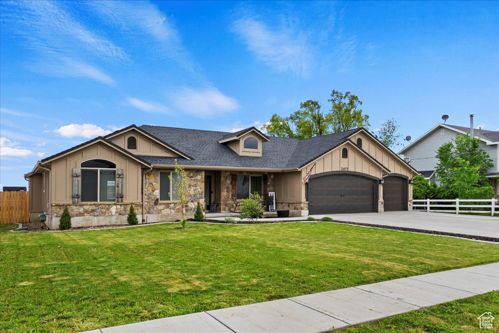 View of front of house featuring a garage and a front yard