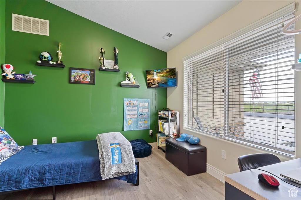 Bedroom featuring hardwood / wood-style floors and vaulted ceiling