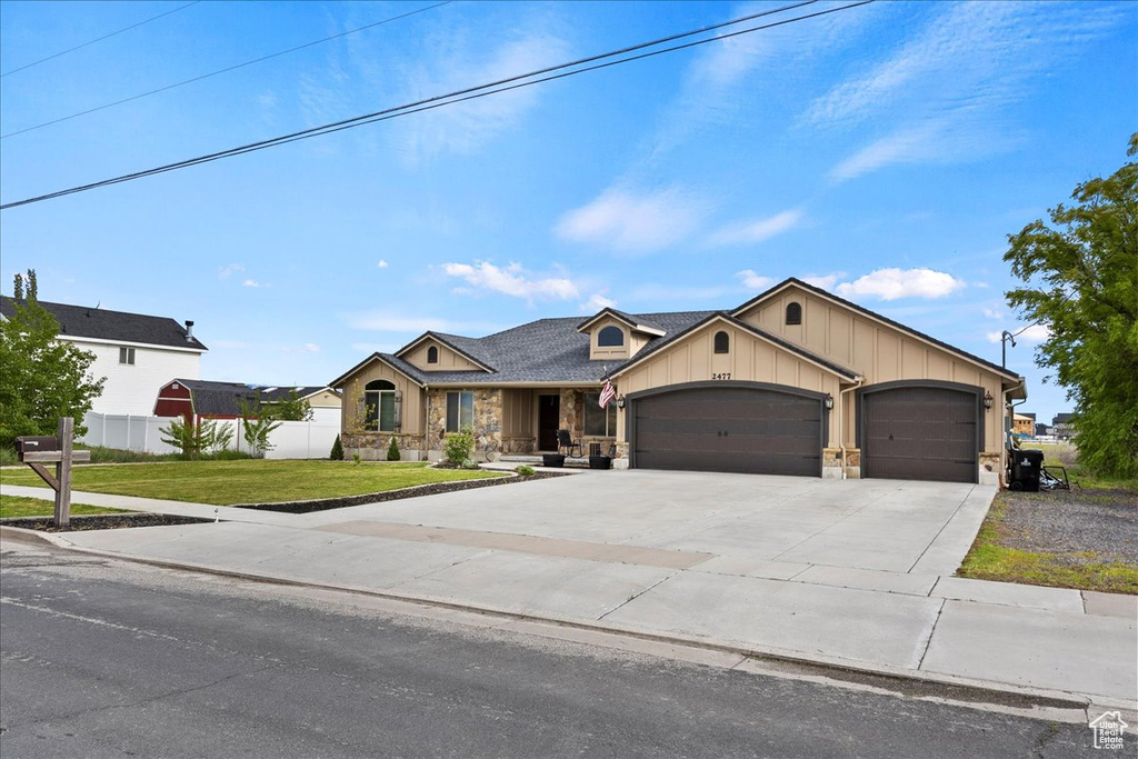 View of front of house featuring a front lawn and a garage