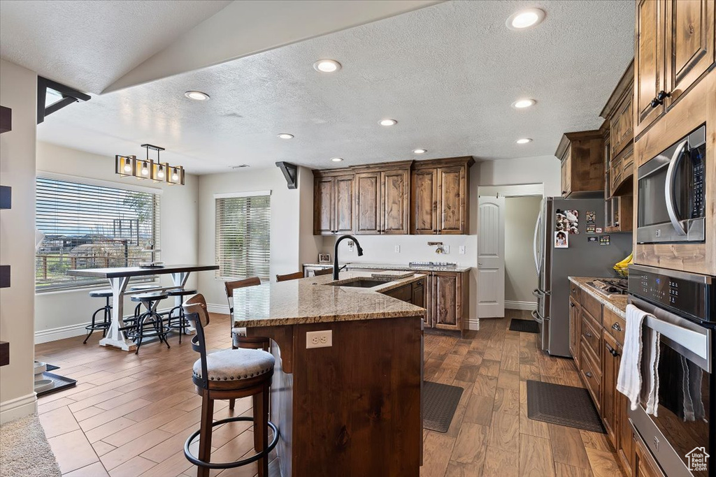 Kitchen with plenty of natural light, appliances with stainless steel finishes, dark hardwood / wood-style floors, and sink