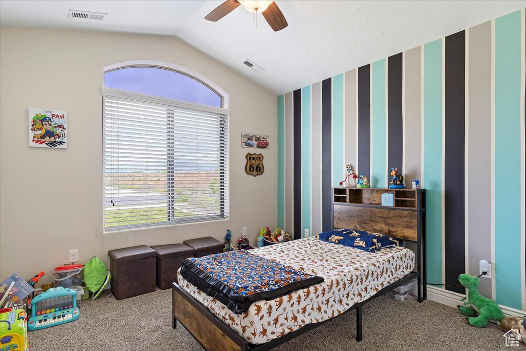 Bedroom with lofted ceiling, ceiling fan, and carpet