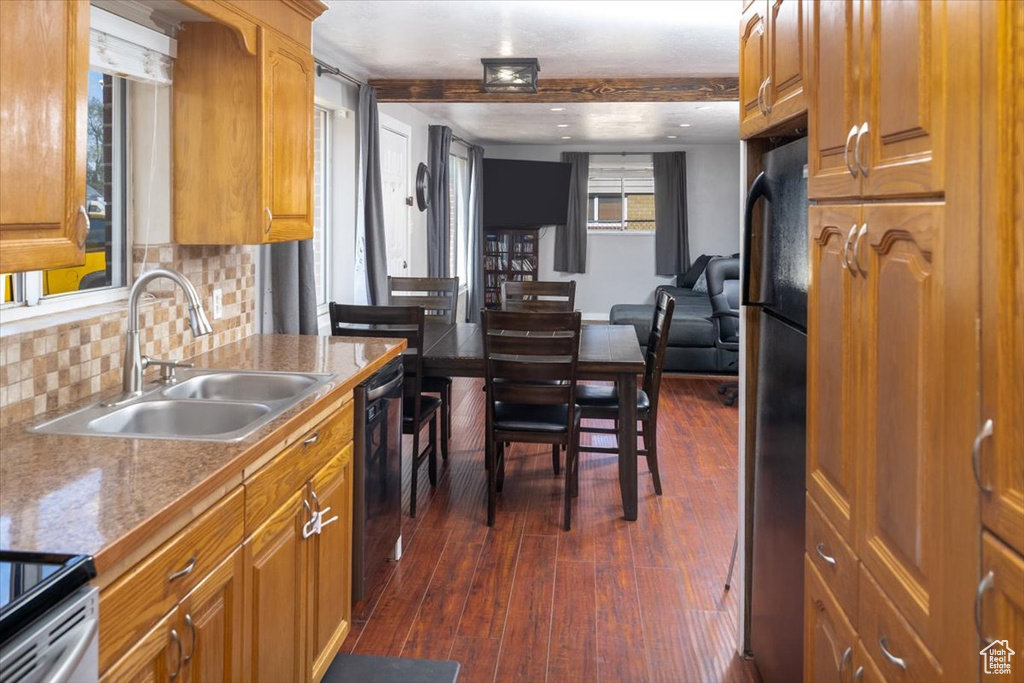 Kitchen featuring backsplash, dishwasher, dark hardwood / wood-style floors, stainless steel fridge, and sink
