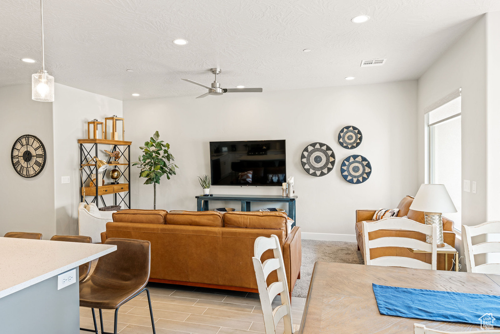 Living room with ceiling fan and a textured ceiling