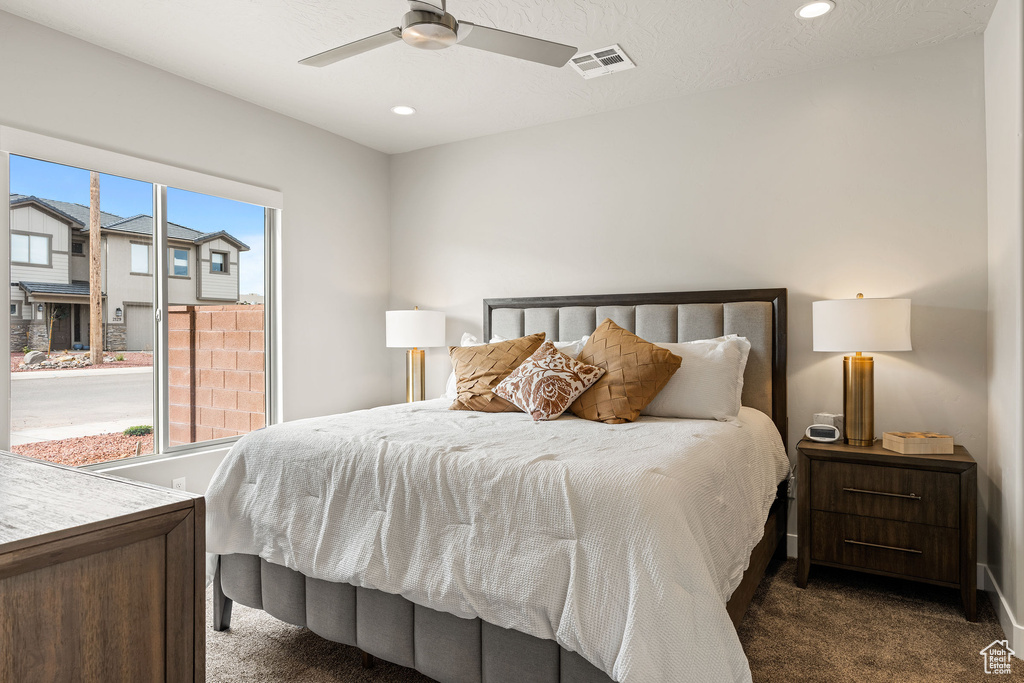 Carpeted bedroom featuring ceiling fan