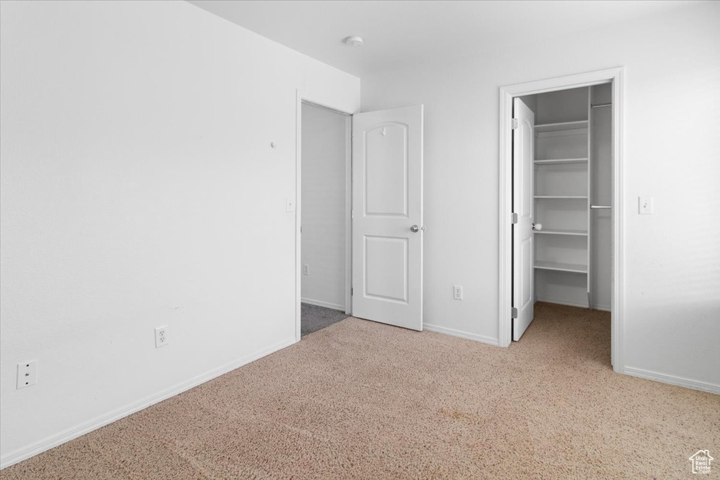Unfurnished bedroom with a spacious closet and carpet flooring