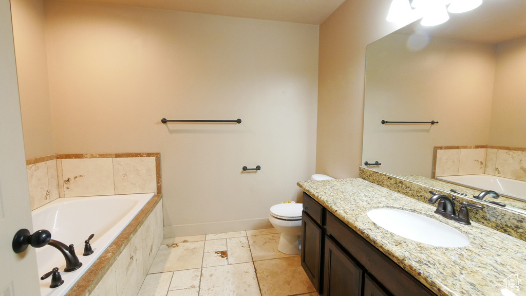 Bathroom with oversized vanity, tile floors, toilet, and tiled tub
