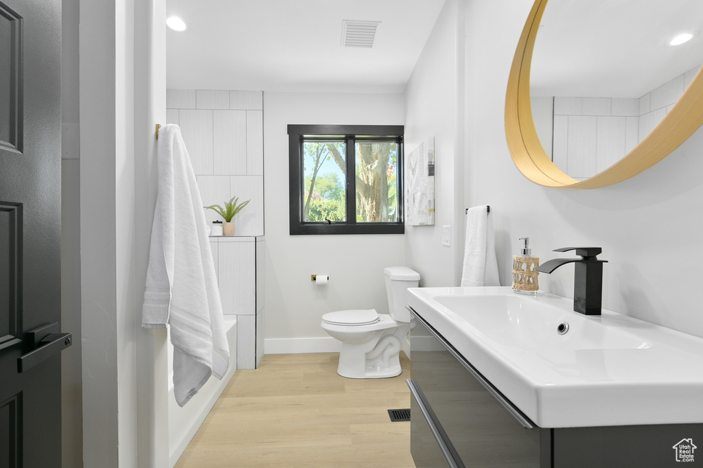 Bathroom with sink, hardwood / wood-style floors, and toilet