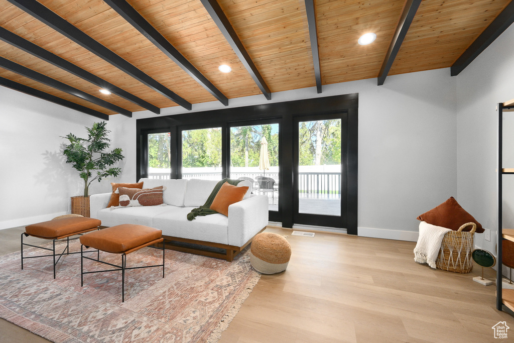 Living room featuring wood ceiling, light hardwood / wood-style floors, and vaulted ceiling with beams