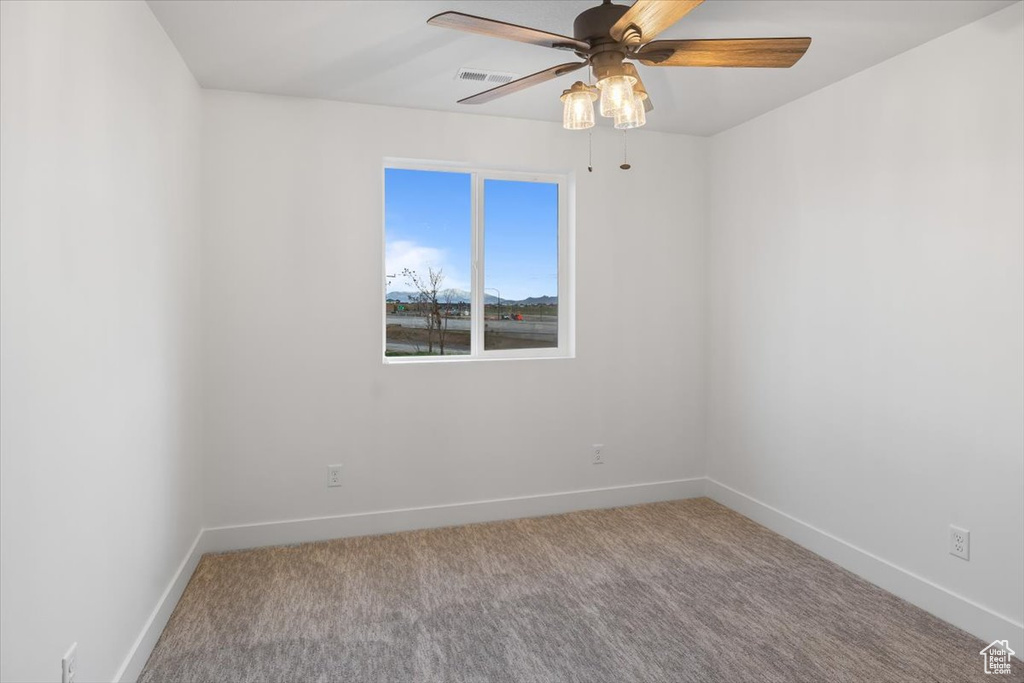 Unfurnished room with ceiling fan and carpet