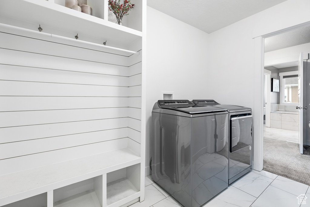 Laundry room featuring washer and clothes dryer, washer hookup, and light tile flooring