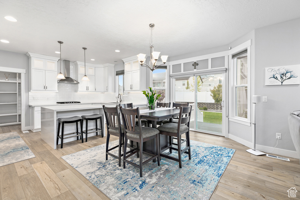 Dining area featuring an inviting chandelier and light wood-type flooring