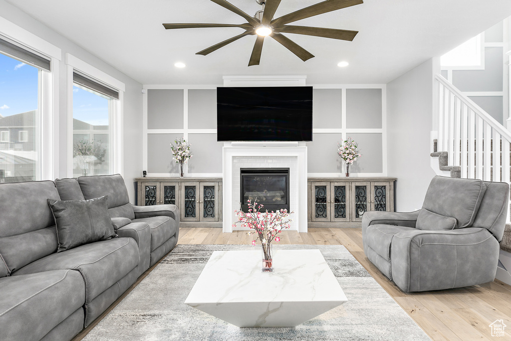 Living room with light hardwood / wood-style flooring and ceiling fan