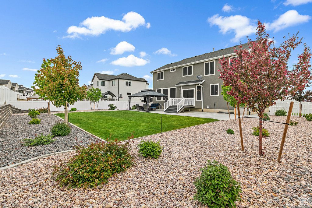 Back of property with a gazebo, a yard, and a patio