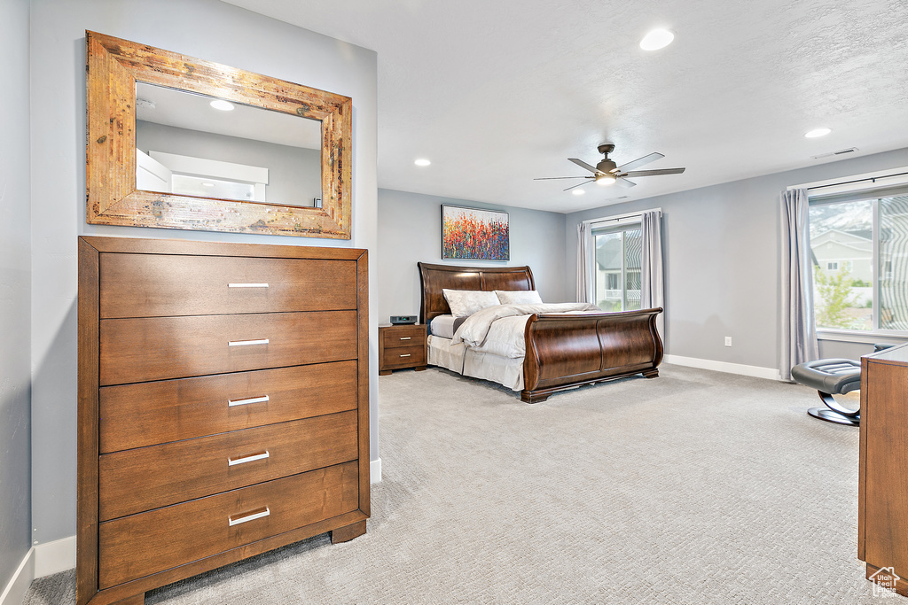 Bedroom with light colored carpet and ceiling fan