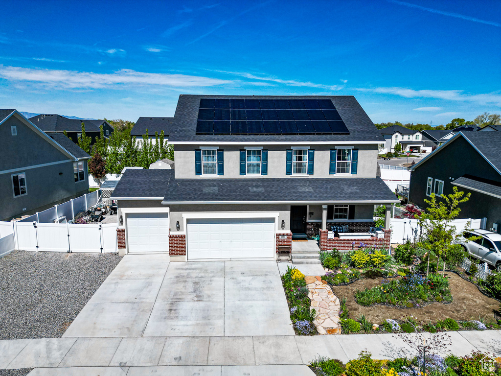 View of front of property with solar panels and a garage