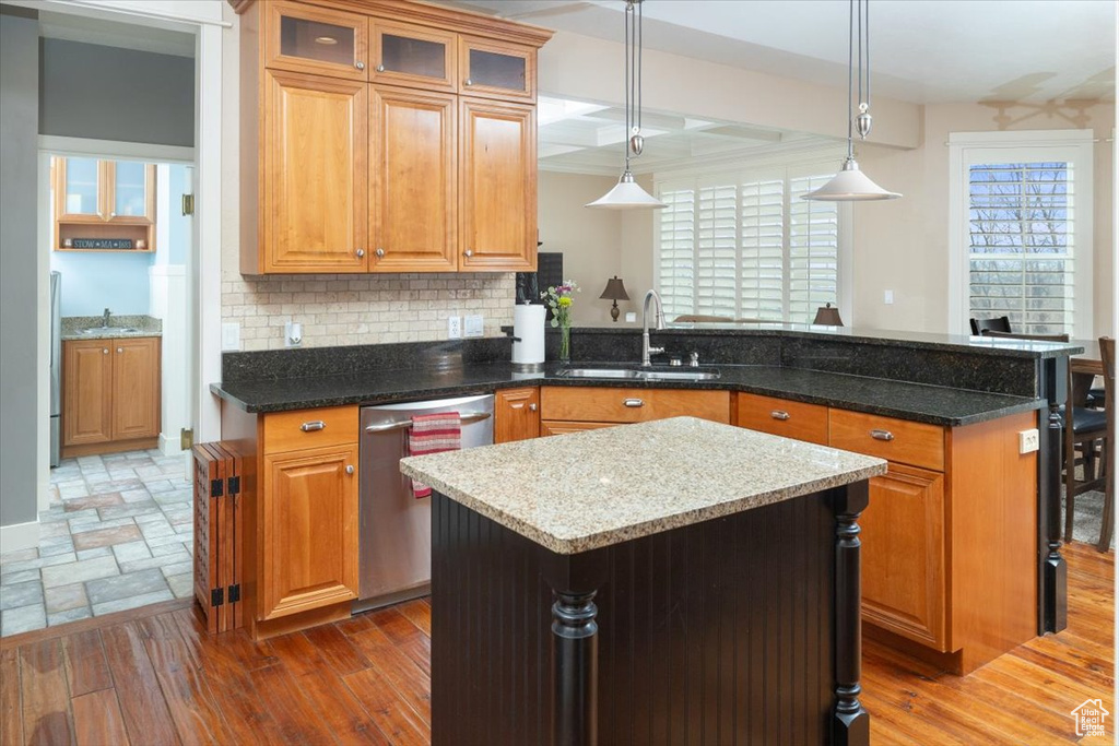 Kitchen featuring a center island, sink, dishwasher, tasteful backsplash, and hardwood / wood-style flooring