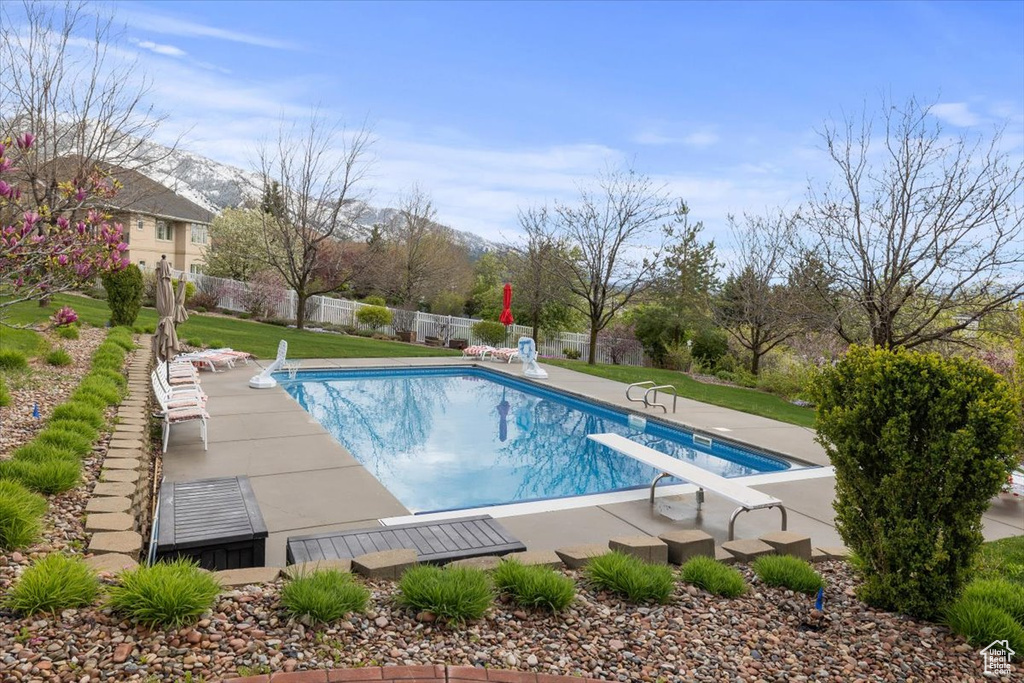 View of pool featuring a diving board and a patio area