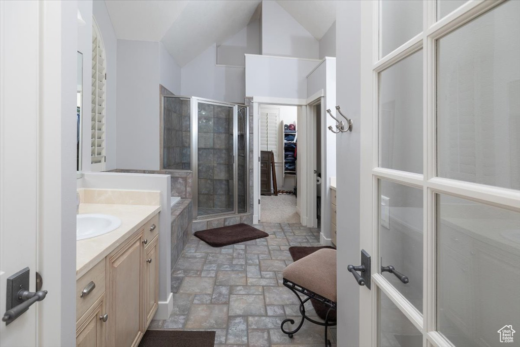 Bathroom featuring tile flooring, vanity, and a shower with shower door