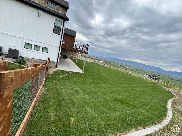 View of yard with central air condition unit, fence, a patio, and a deck