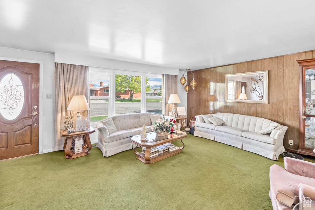 Carpeted living room with wood walls