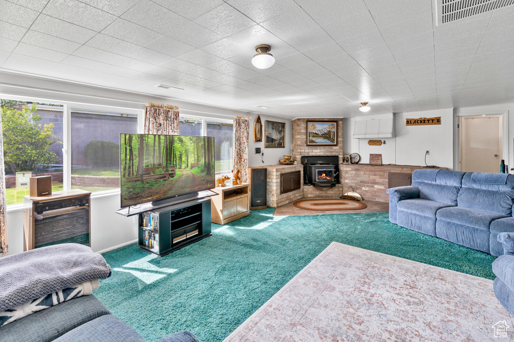 Carpeted living room featuring a fireplace and a wood stove