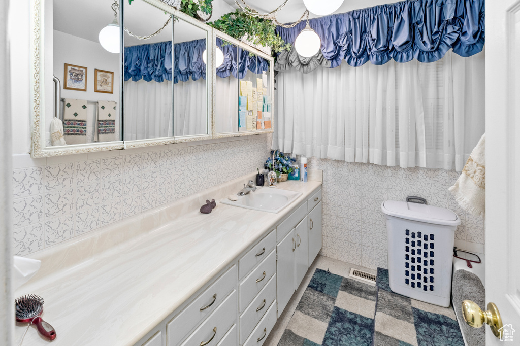 Bathroom featuring tile walls, vanity, and tile floors