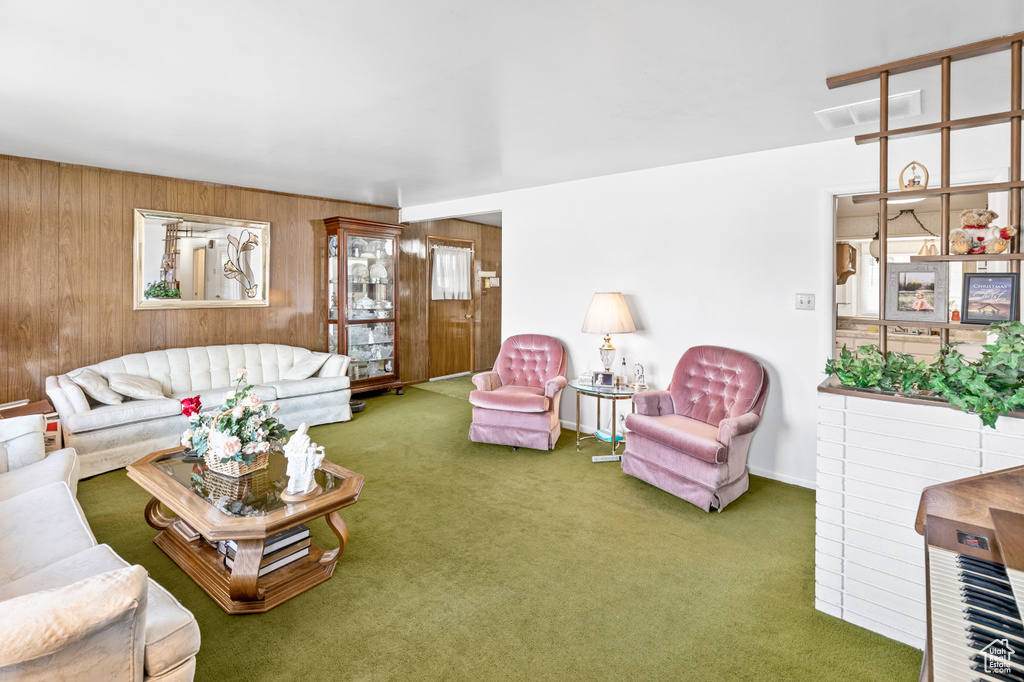 Carpeted living room with wooden walls