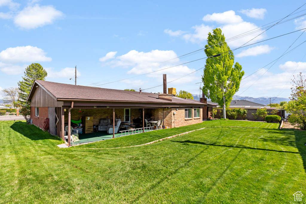 Back of property featuring a lawn and a patio area