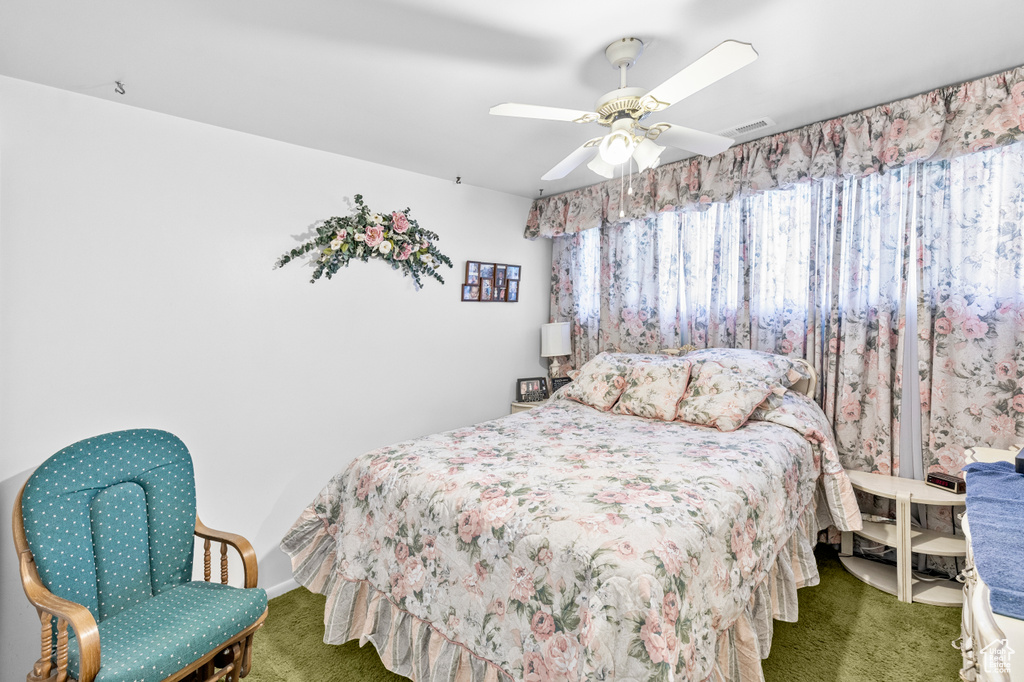 Carpeted bedroom featuring ceiling fan