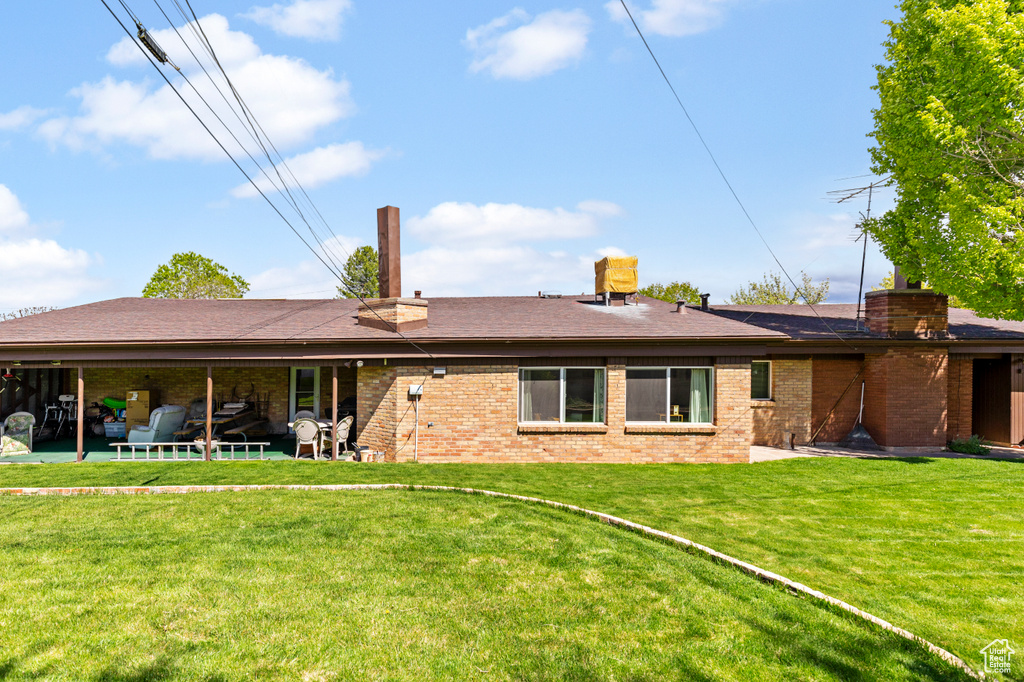 Back of property featuring a lawn and a patio area