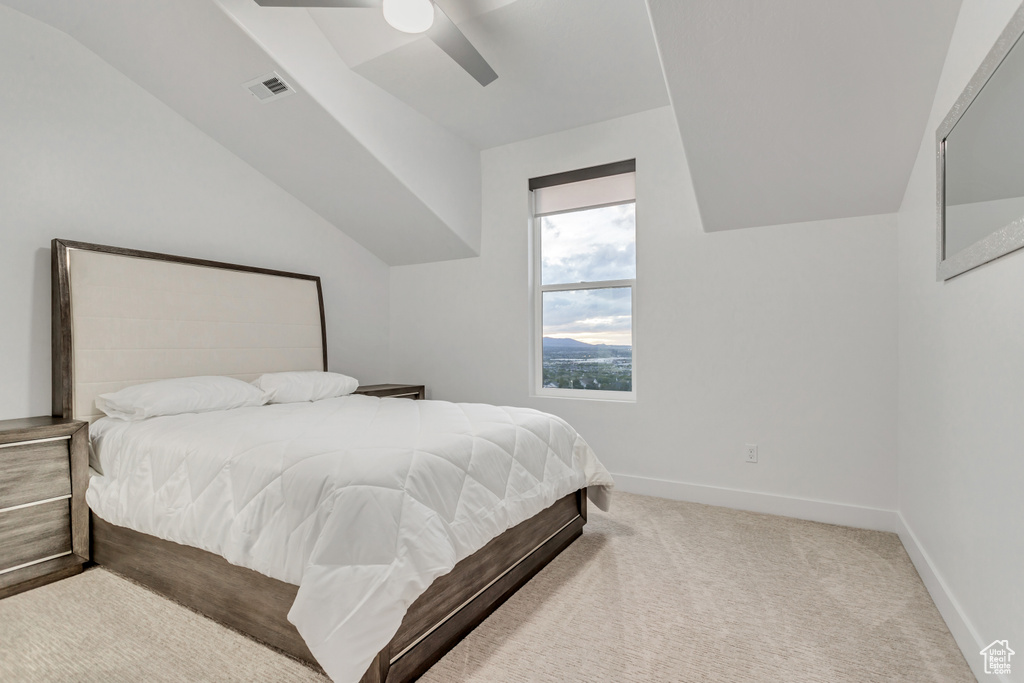 Bedroom with vaulted ceiling, carpet floors, and ceiling fan