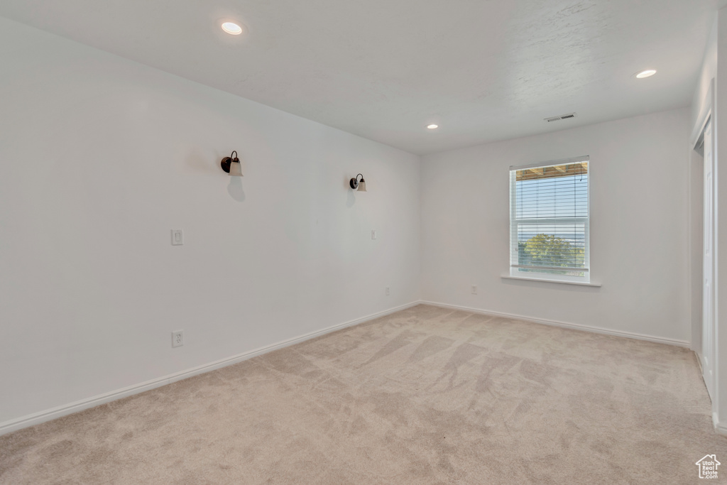 Empty room featuring light carpet