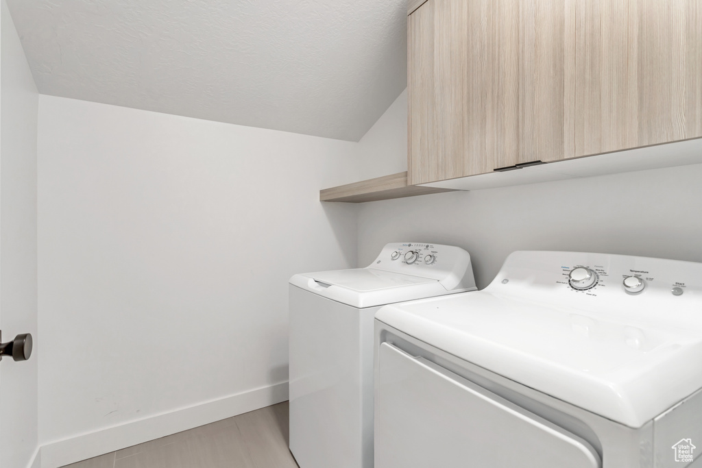 Washroom featuring cabinets and independent washer and dryer