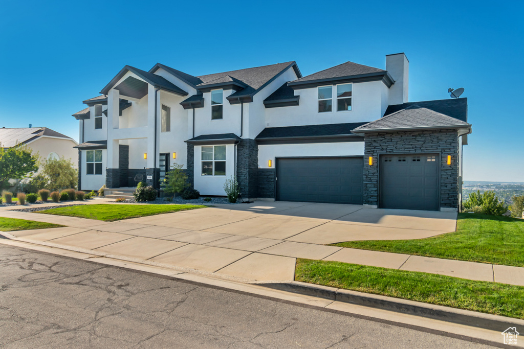 View of front of home featuring a garage and a front lawn