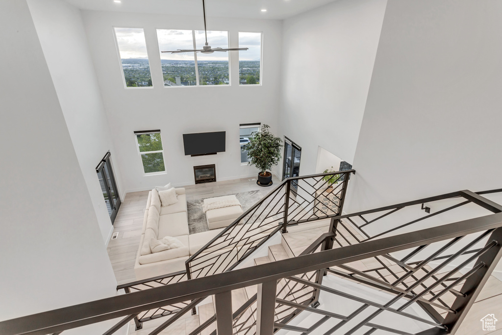 Entrance foyer with ceiling fan, a high ceiling, and light wood-type flooring