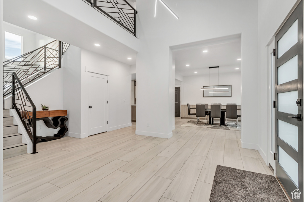 Entrance foyer with a towering ceiling and light hardwood / wood-style floors