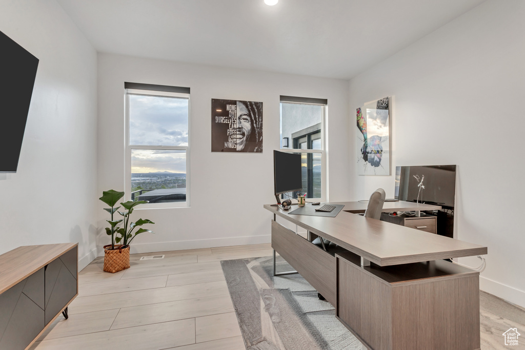 Home office with light hardwood / wood-style floors