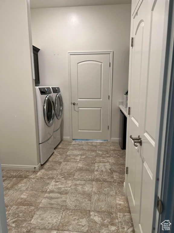 Laundry room with cabinets, separate washer and dryer, and light tile floors