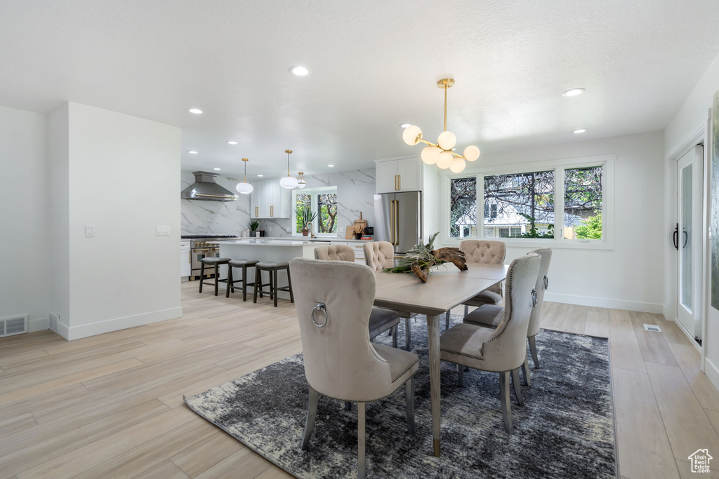 Dining area featuring light hardwood / wood-style floors and an inviting chandelier