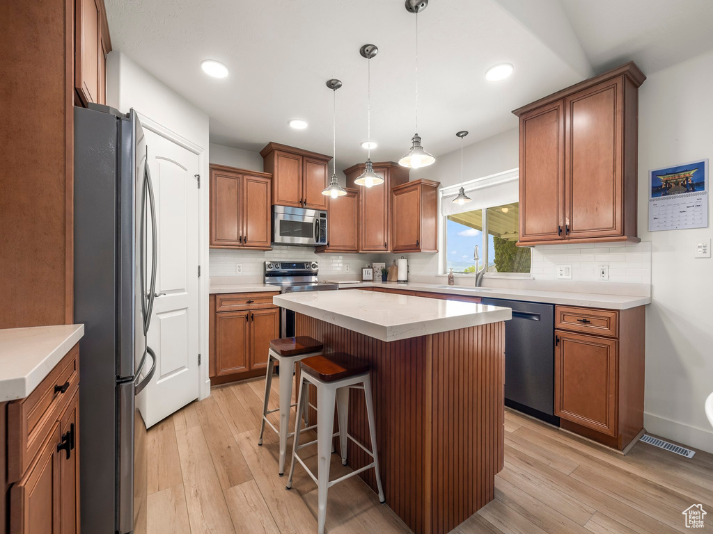 Kitchen featuring light hardwood / wood-style flooring, backsplash, and stainless steel appliances